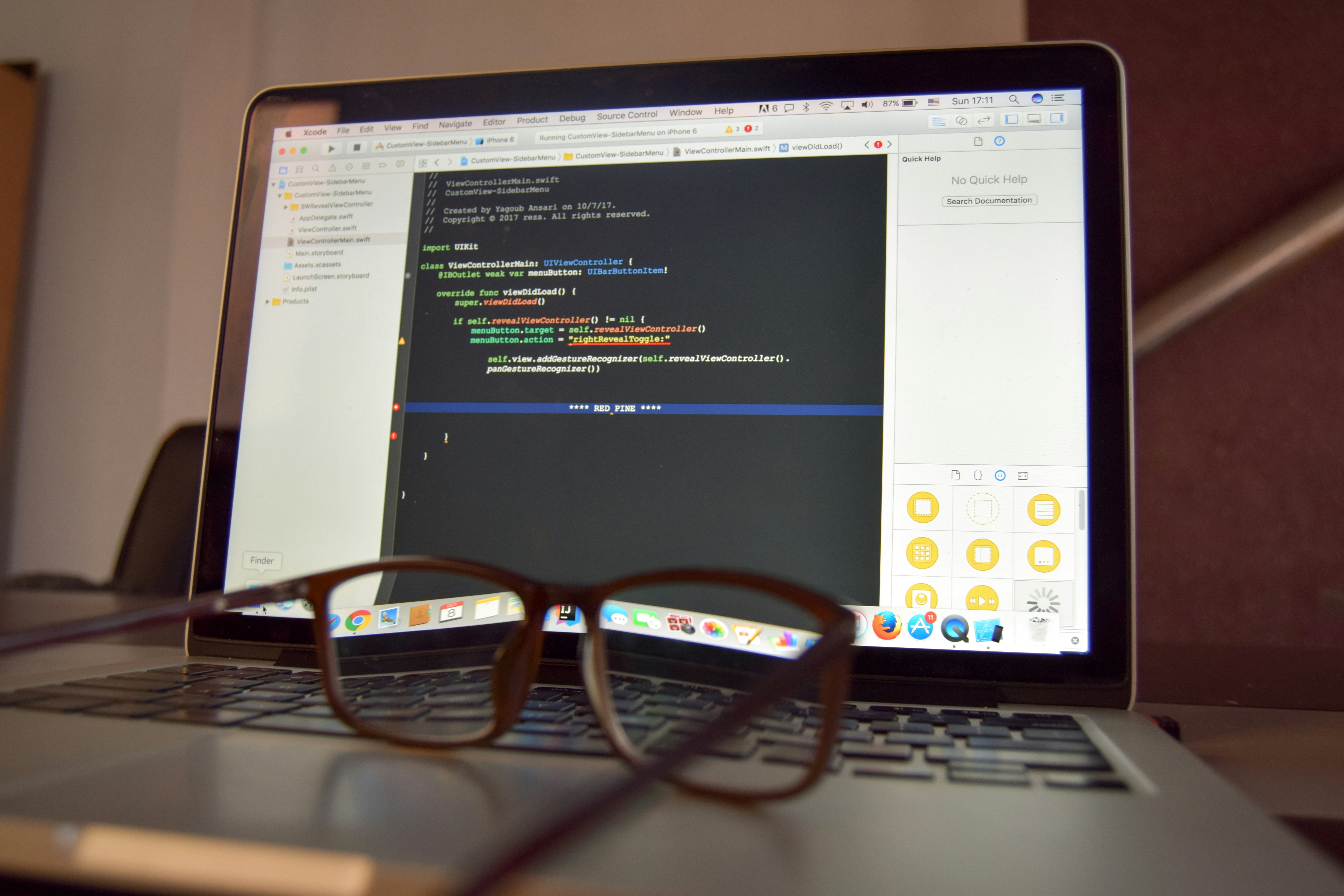 Eyeglasses in front of a laptop displaying Xcode