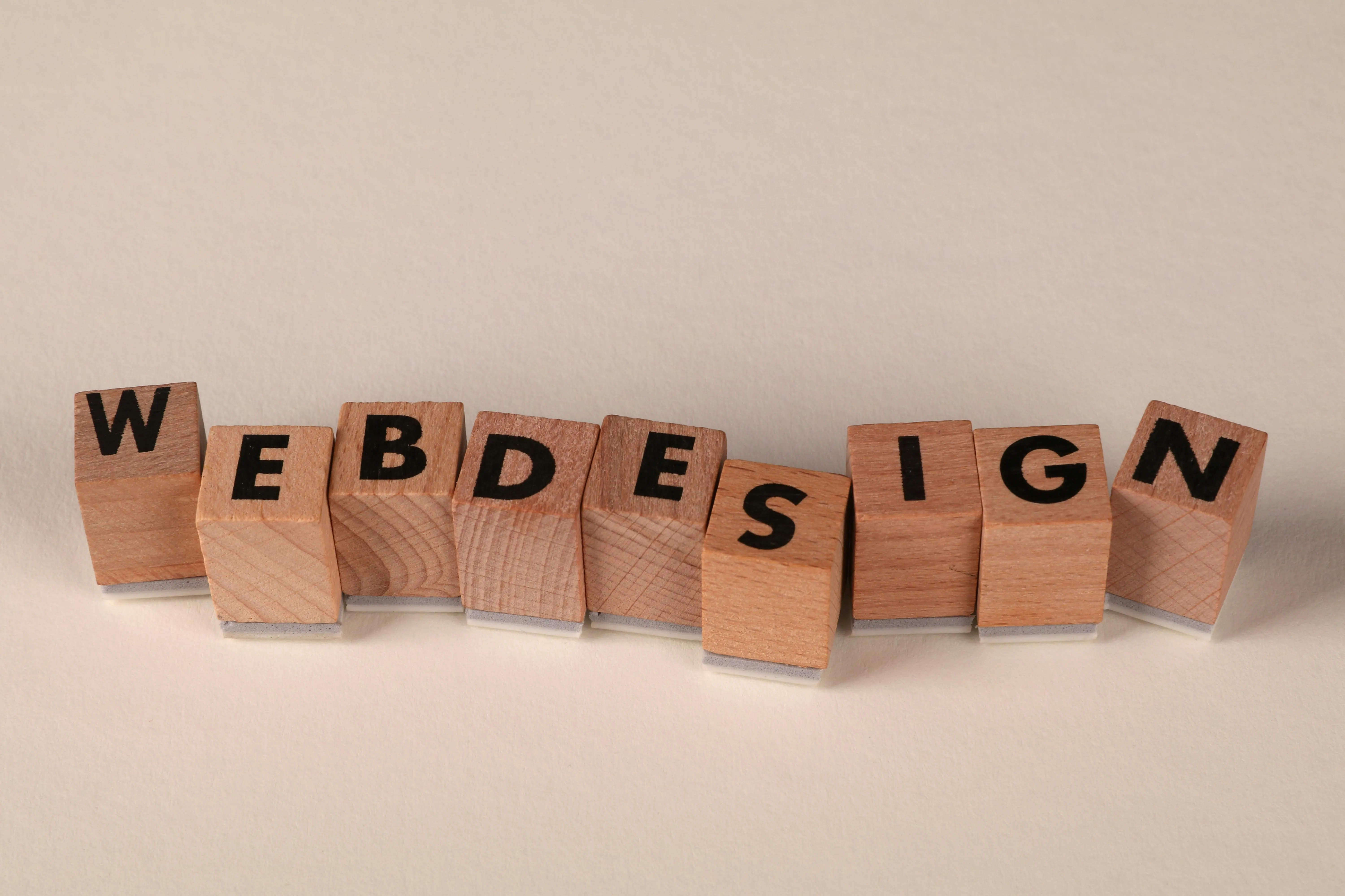 Wooden blocks spelling 'WEB DESIGN' on a light surface.