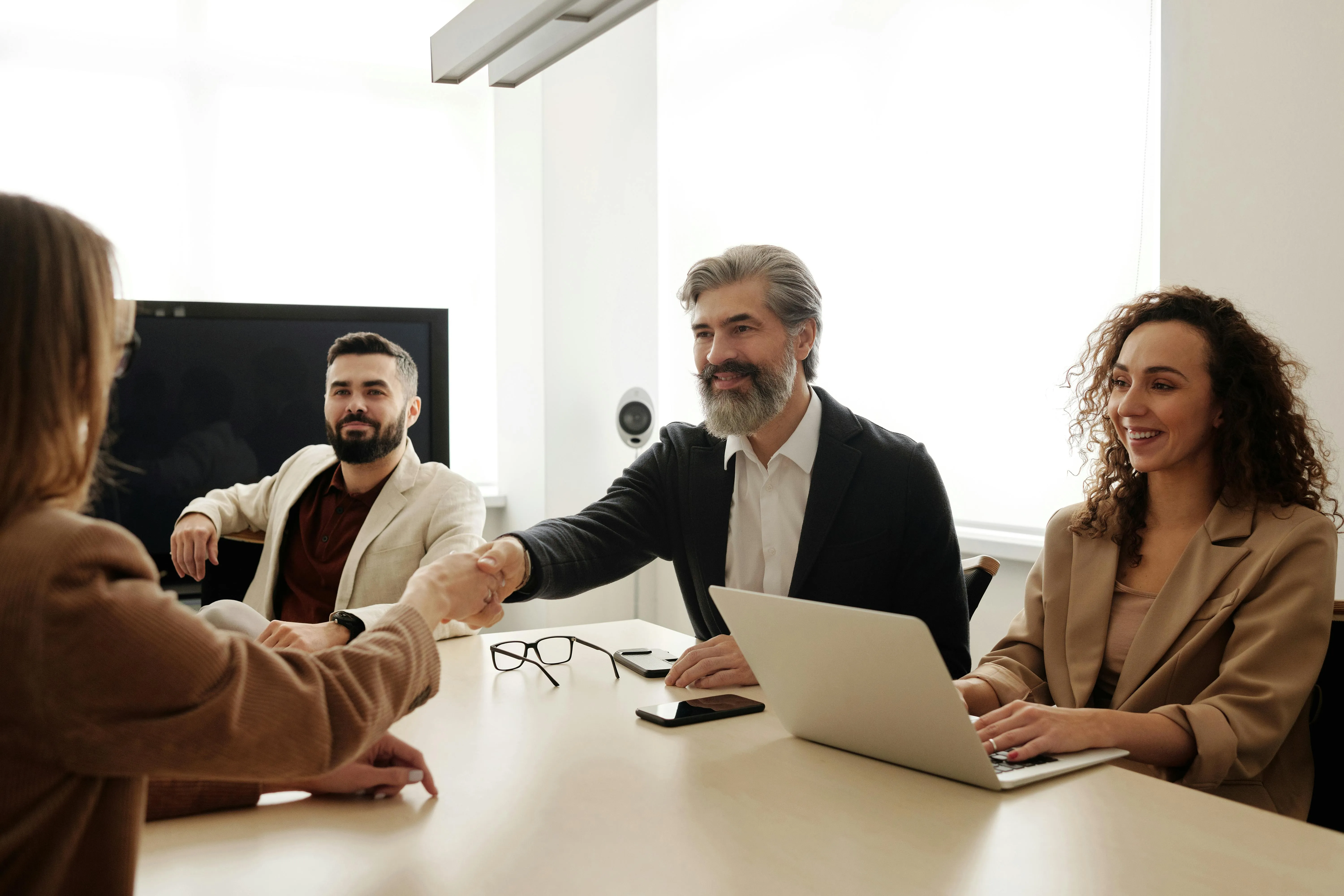 Professional meeting with a handshake in a modern office.