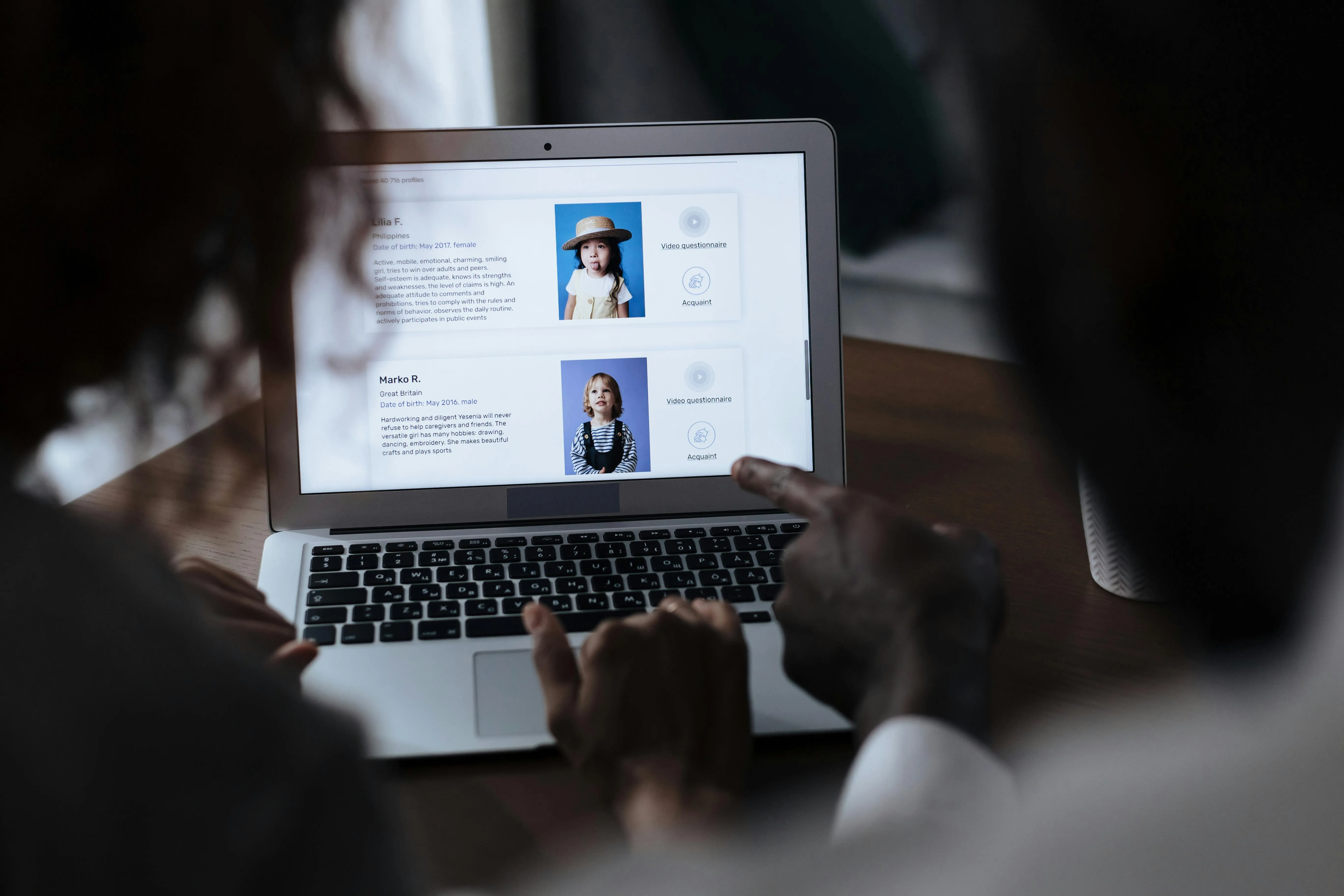 Laptop screen showing child profiles with interactive options.