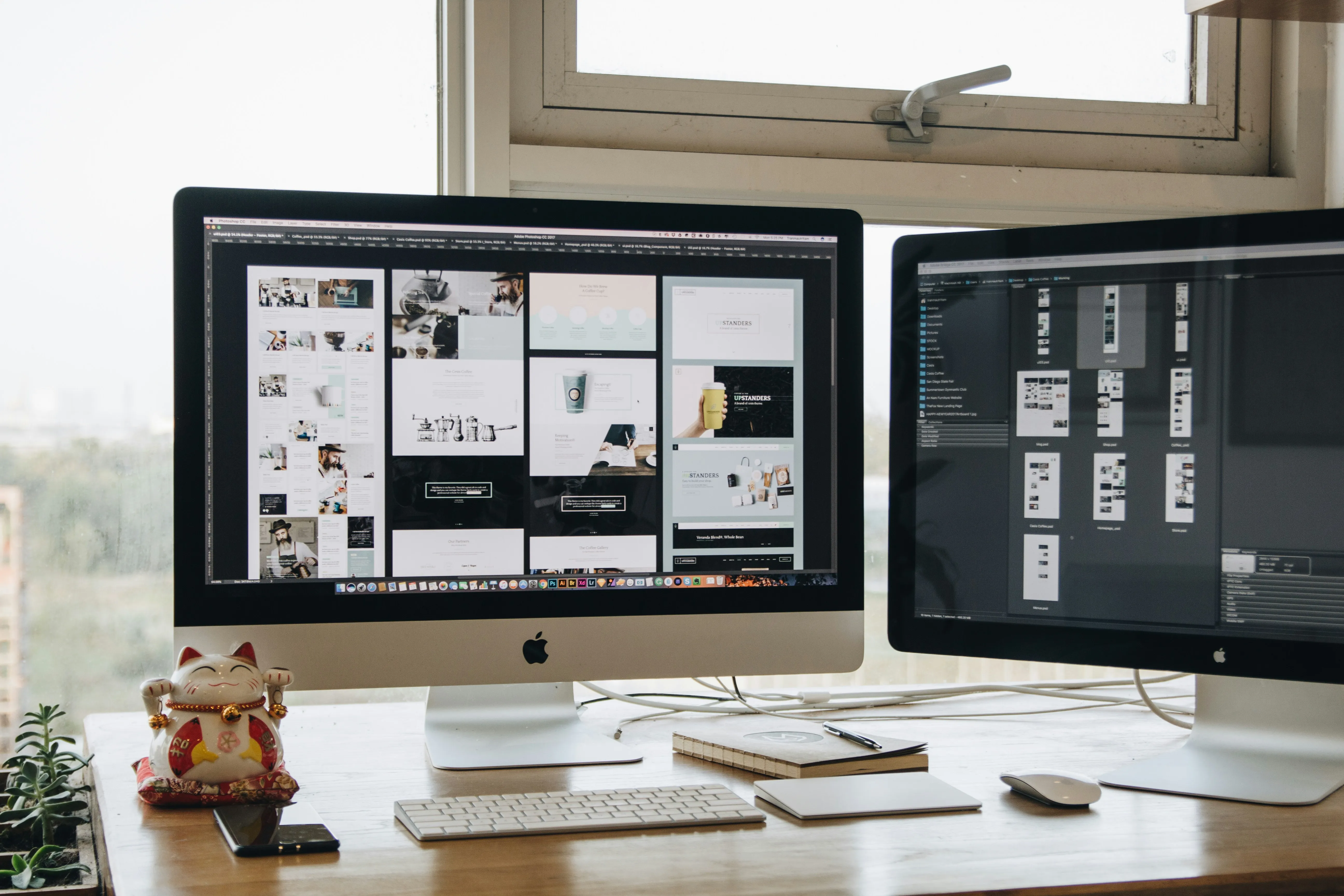 Creative workspace with dual monitors displaying design layouts.​