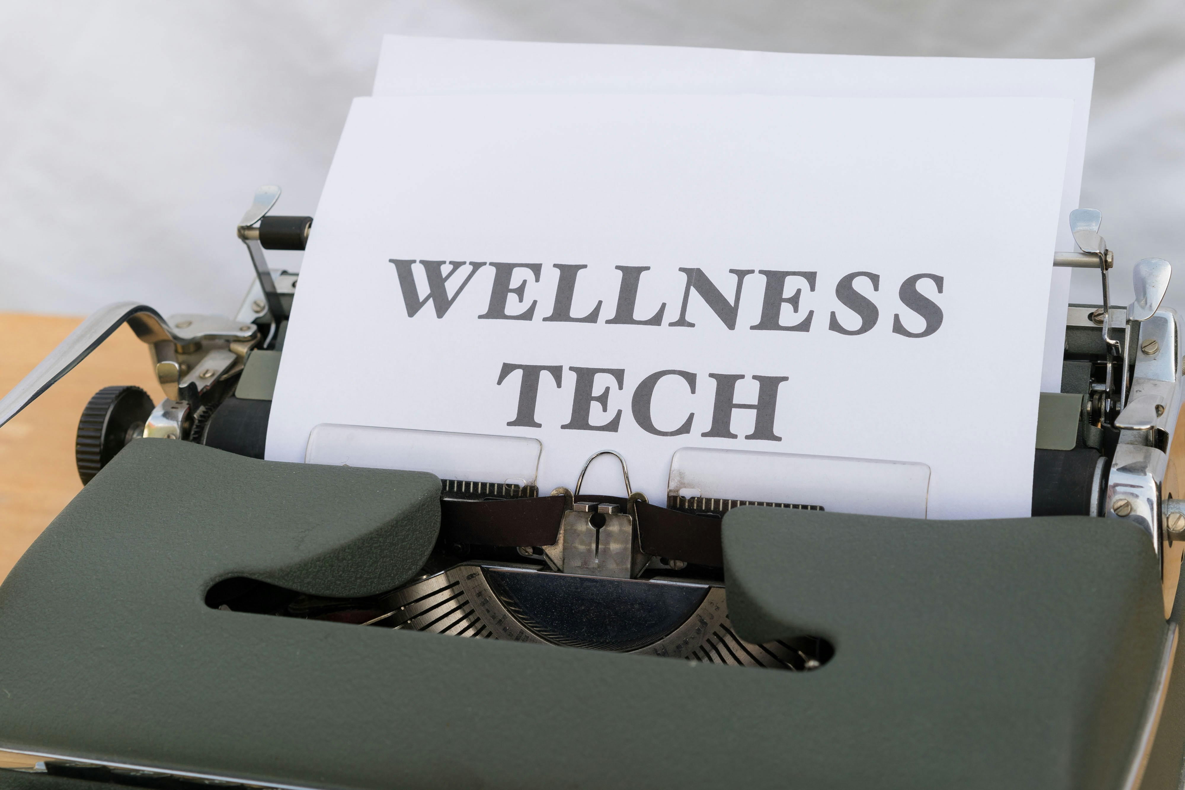 A vintage typewriter with a sheet of paper displaying wellness tech