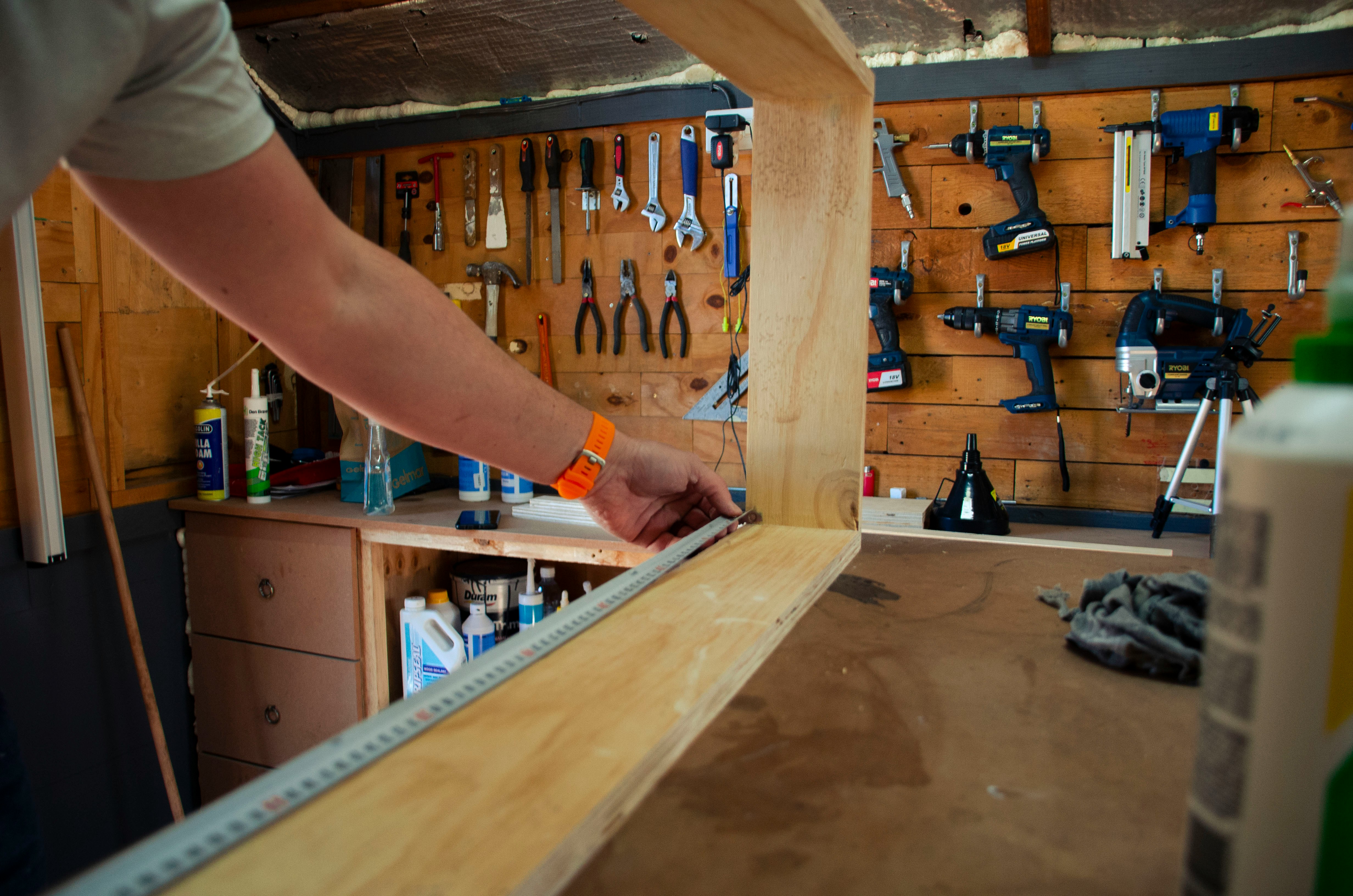 A person measuring wood with a ruler showcasing practical woodworking design and planning.
